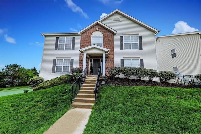 view of front of home with a front yard and brick siding