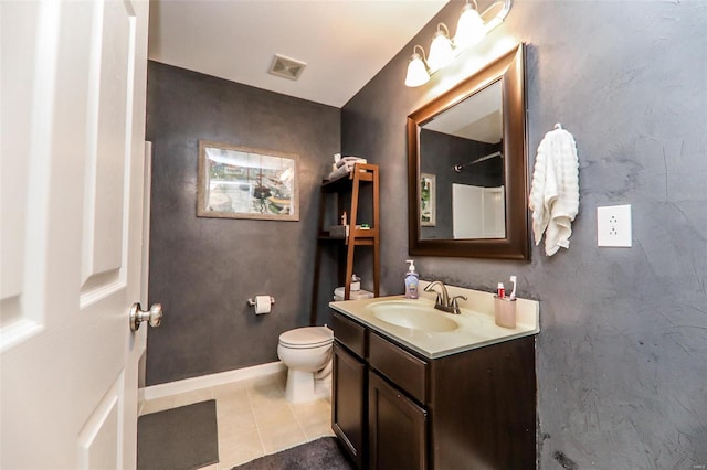 bathroom featuring toilet, vanity, baseboards, visible vents, and tile patterned floors