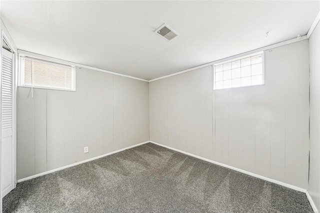 below grade area with baseboards, visible vents, and carpet floors