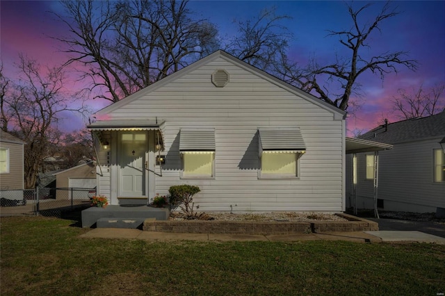 view of front of property with a lawn and fence