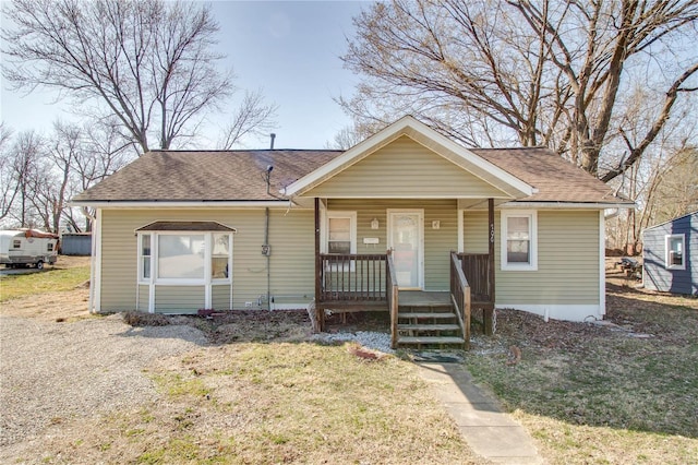 bungalow with a porch and a shingled roof