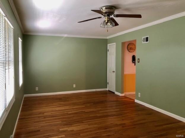 unfurnished room featuring visible vents, crown molding, baseboards, wood finished floors, and a ceiling fan