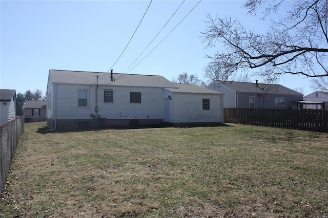 back of property with a lawn and a fenced backyard