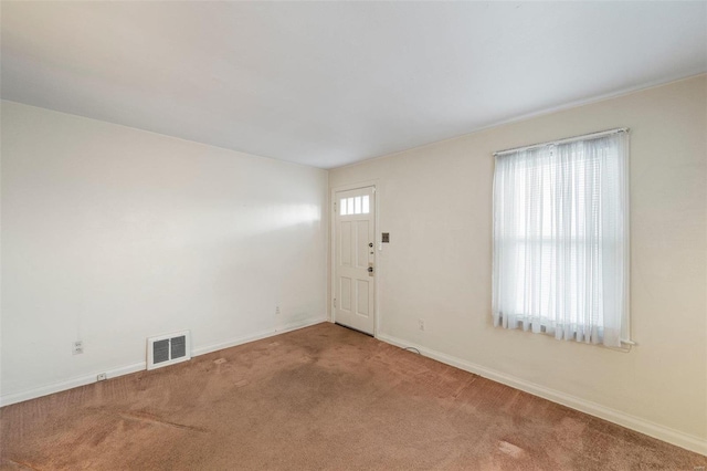 carpeted spare room featuring visible vents and baseboards