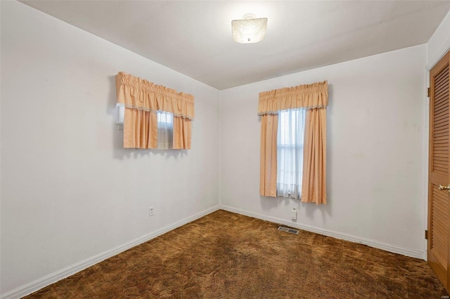 carpeted empty room with visible vents and baseboards