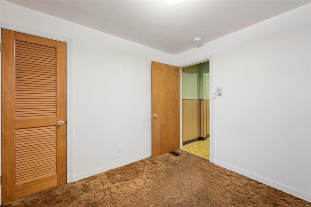 unfurnished bedroom with a closet, baseboards, and carpet floors