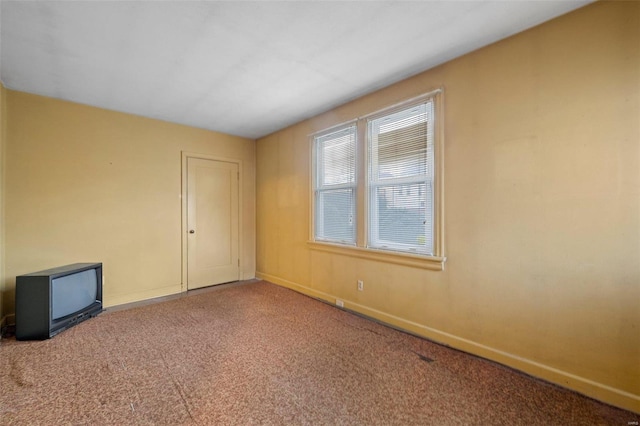 carpeted spare room with baseboards