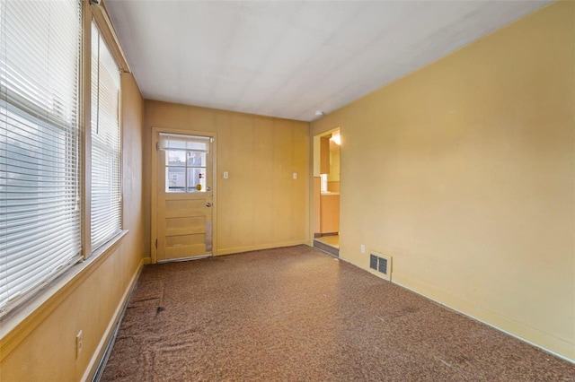 carpeted spare room with baseboards and visible vents