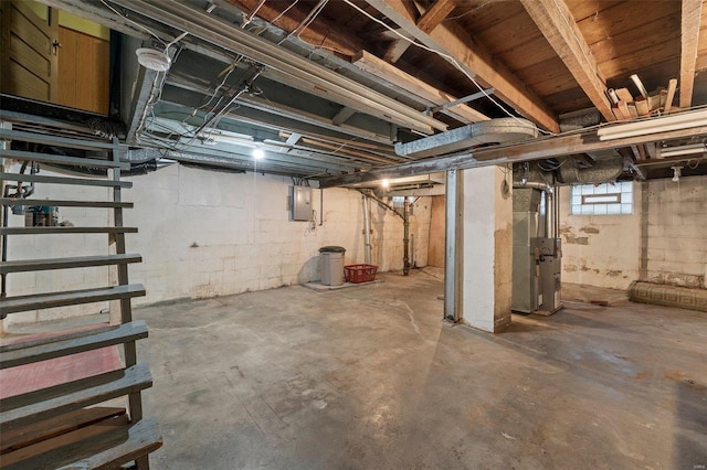 basement featuring electric panel and heating unit