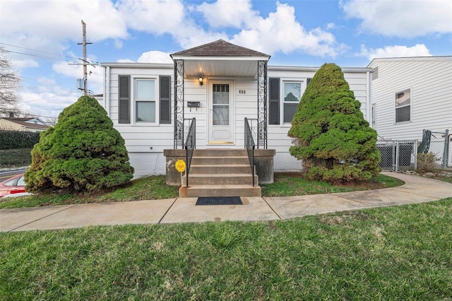 view of front of house with a front lawn and fence