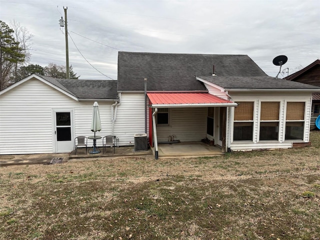 back of house with a shingled roof, a patio area, a lawn, and central AC unit