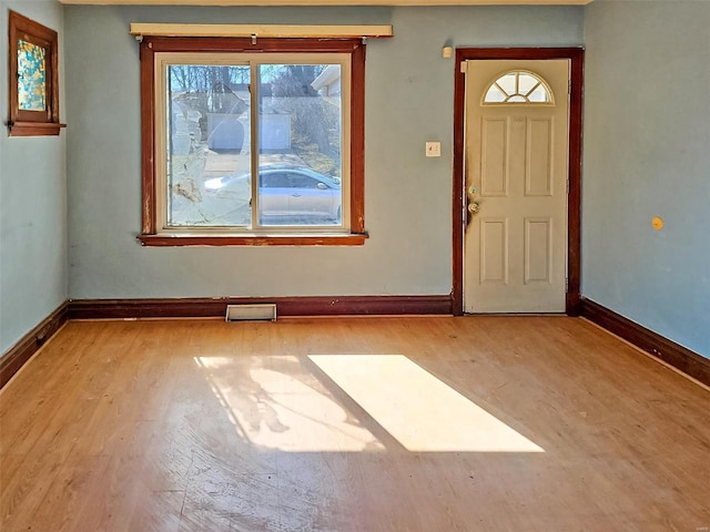 foyer entrance featuring baseboards, visible vents, and light wood finished floors