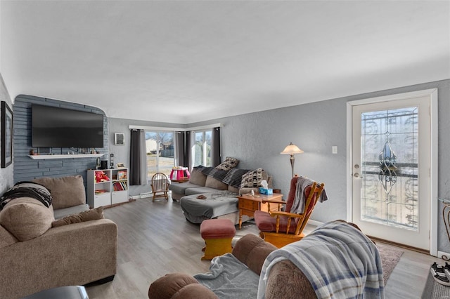 living area featuring baseboards, wood finished floors, and a textured wall