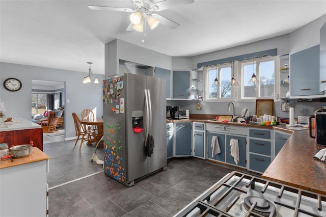 kitchen with dark countertops, open shelves, stainless steel refrigerator with ice dispenser, and a sink