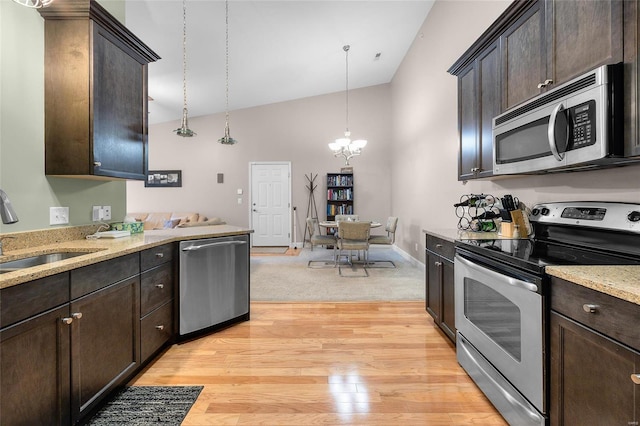 kitchen with light wood-style flooring, a sink, dark brown cabinetry, appliances with stainless steel finishes, and a notable chandelier