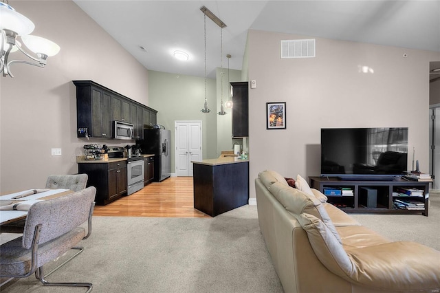 living room featuring high vaulted ceiling, a notable chandelier, visible vents, and light carpet