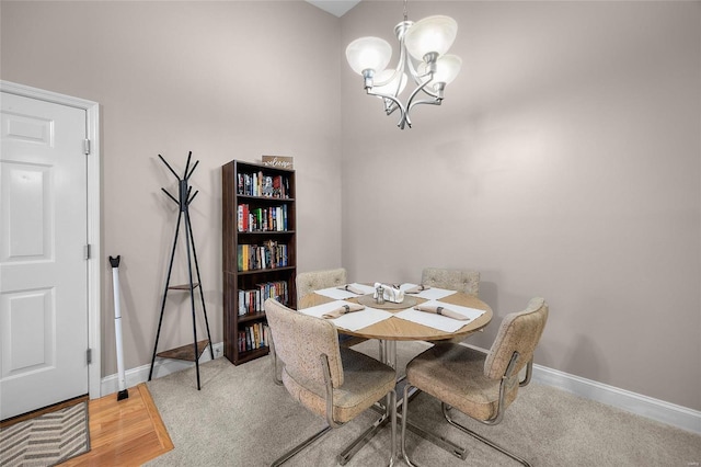 dining room with carpet flooring, baseboards, and an inviting chandelier