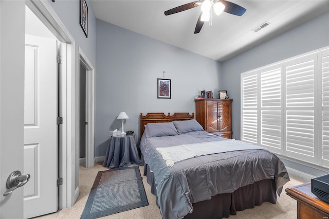 bedroom with visible vents, baseboards, light colored carpet, vaulted ceiling, and a ceiling fan