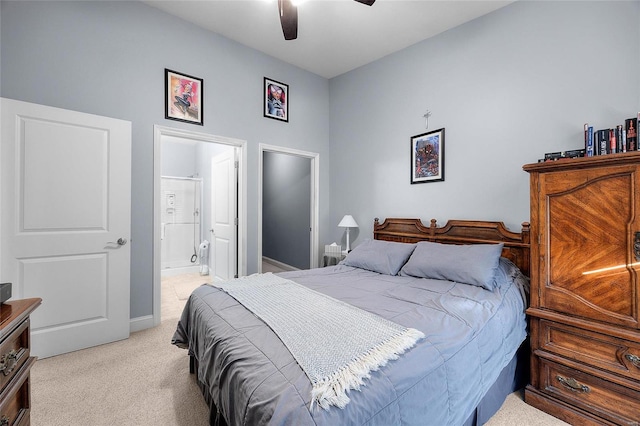 bedroom featuring ceiling fan, baseboards, light carpet, and ensuite bath