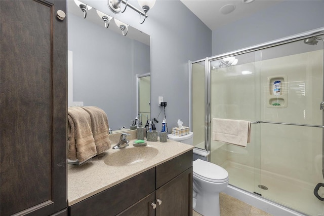 bathroom with tile patterned floors, vanity, toilet, and a shower stall