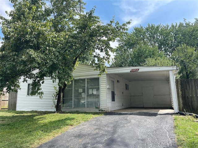 view of front of property featuring aphalt driveway, a front yard, fence, and an attached carport