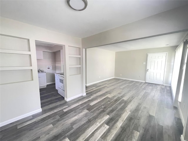 empty room with baseboards and dark wood-style flooring