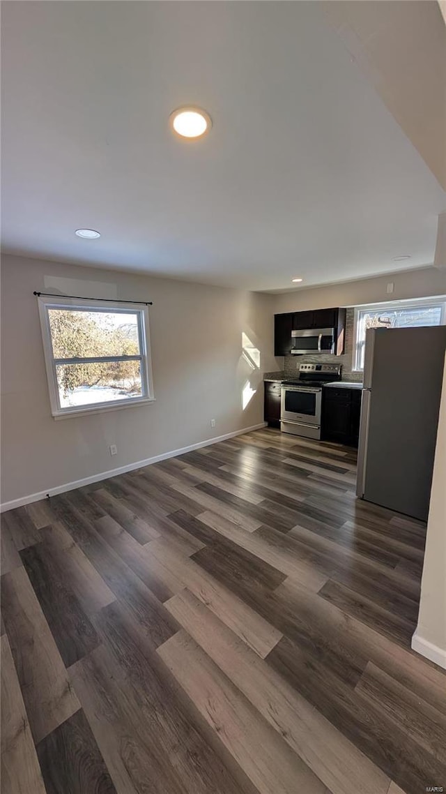 unfurnished living room featuring dark wood-type flooring, recessed lighting, and baseboards