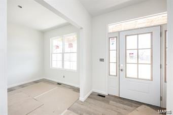 foyer with baseboards and wood finished floors