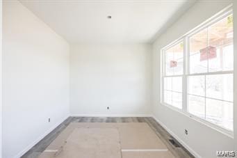 unfurnished room with baseboards