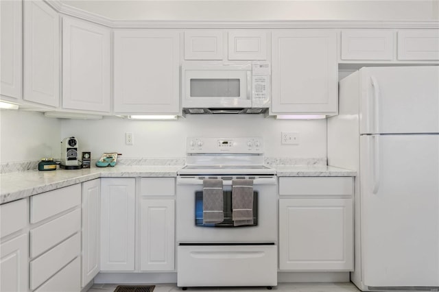 kitchen with white appliances, white cabinetry, and light stone countertops