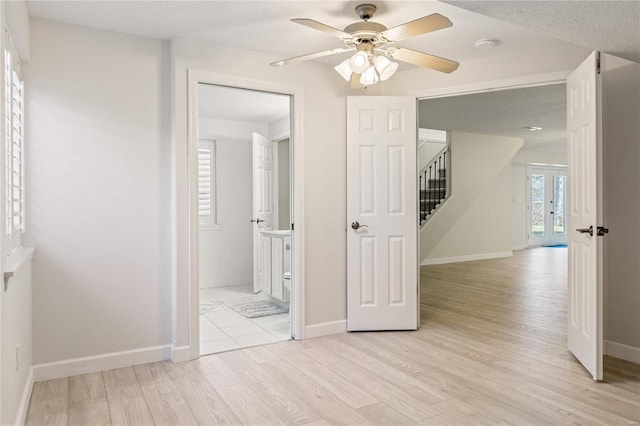 interior space with stairway, light wood-style flooring, and baseboards