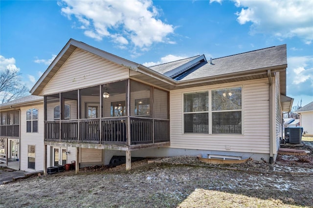 rear view of property with central air condition unit and a sunroom