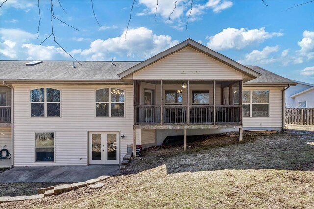 back of house with a shingled roof, fence, a sunroom, french doors, and a patio area