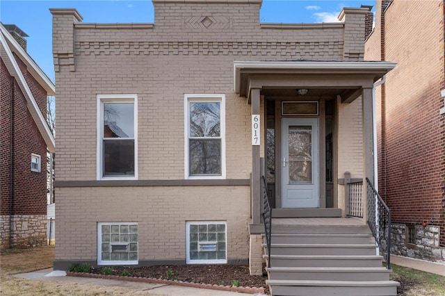 doorway to property featuring brick siding