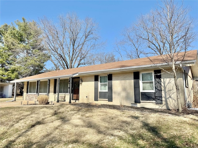 ranch-style house featuring brick siding and a front lawn