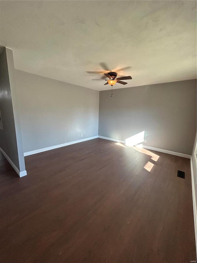 unfurnished room featuring visible vents, baseboards, dark wood finished floors, ceiling fan, and a textured ceiling