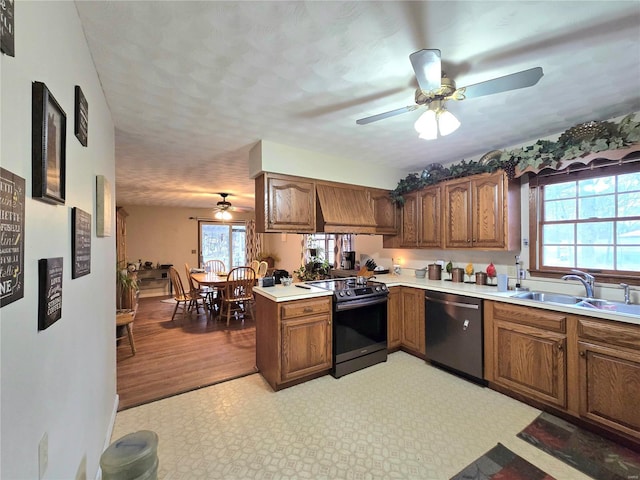 kitchen featuring brown cabinets, light countertops, electric range oven, a sink, and dishwasher