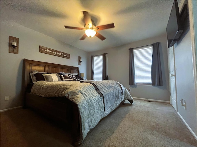 carpeted bedroom with a ceiling fan, baseboards, and a textured ceiling