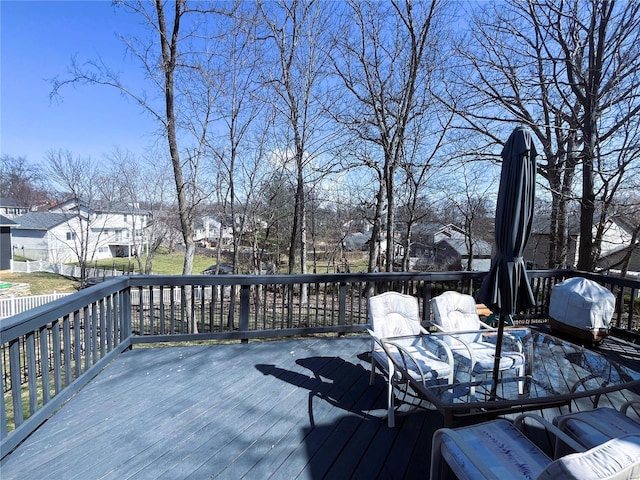 wooden deck with area for grilling, outdoor dining area, and a residential view