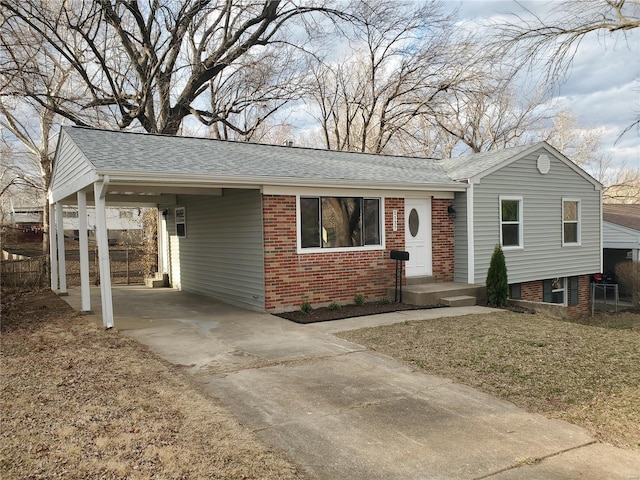 ranch-style home with concrete driveway, a carport, a shingled roof, and brick siding