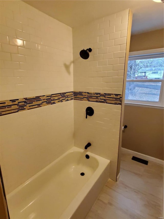 full bath featuring shower / bath combination, visible vents, and baseboards