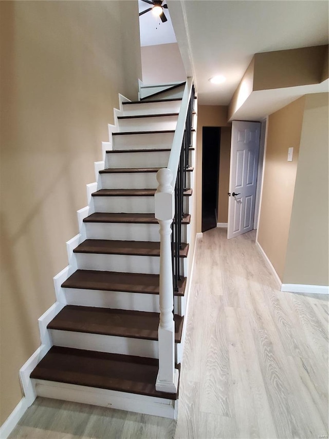 stairway featuring baseboards and wood finished floors