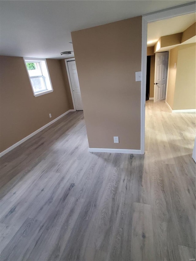 unfurnished room with baseboards and light wood-style floors