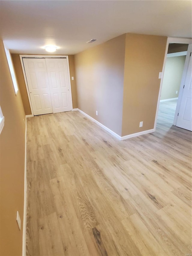 spare room with visible vents, light wood-style flooring, and baseboards