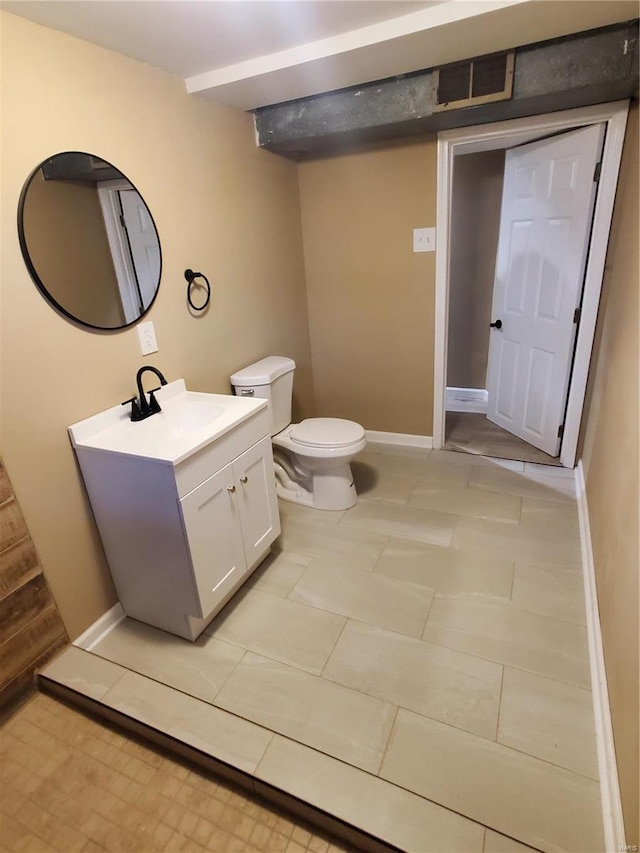 bathroom with toilet, visible vents, baseboards, and vanity