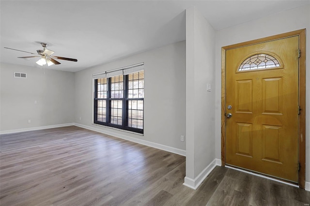 foyer with a ceiling fan, baseboards, visible vents, and dark wood-type flooring