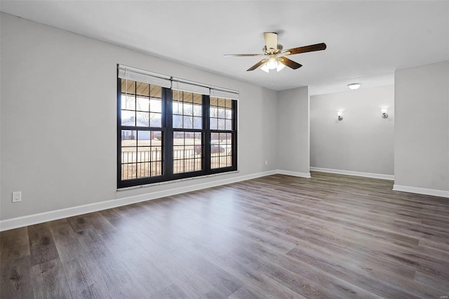 spare room with a ceiling fan, baseboards, and wood finished floors