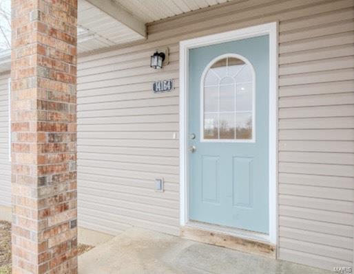 doorway to property with brick siding