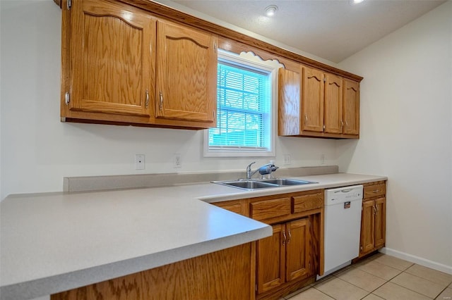 kitchen featuring light tile patterned floors, brown cabinetry, white dishwasher, light countertops, and a sink