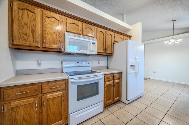 kitchen featuring white appliances, brown cabinets, a textured ceiling, and light tile patterned floors